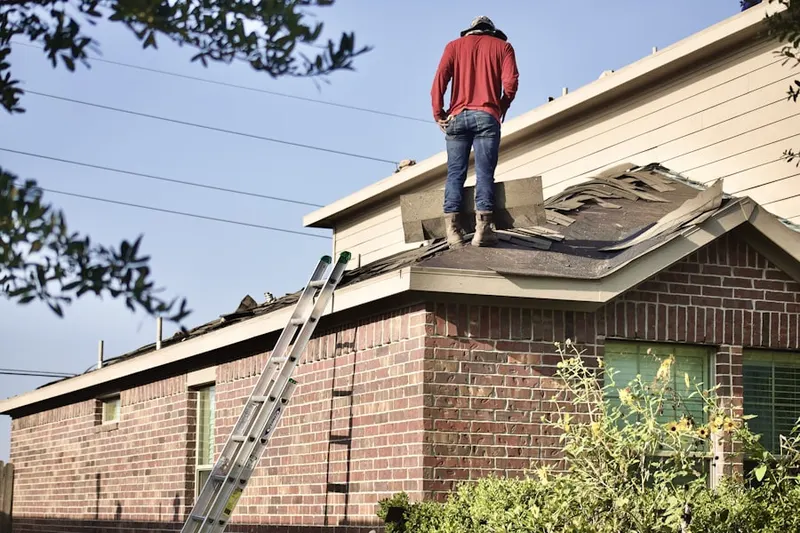 Professional roofer working on a residential roof in Artesia